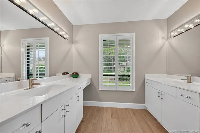 a spacious bathroom with a granite countertop sink mirror and a bathtub