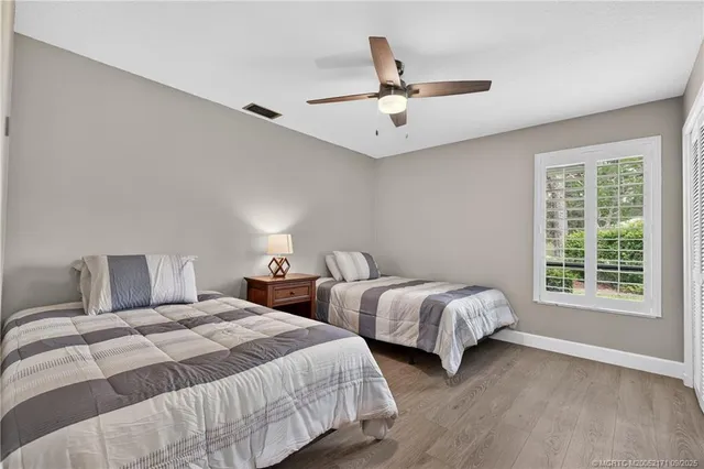 a bedroom with two beds and ceiling fan