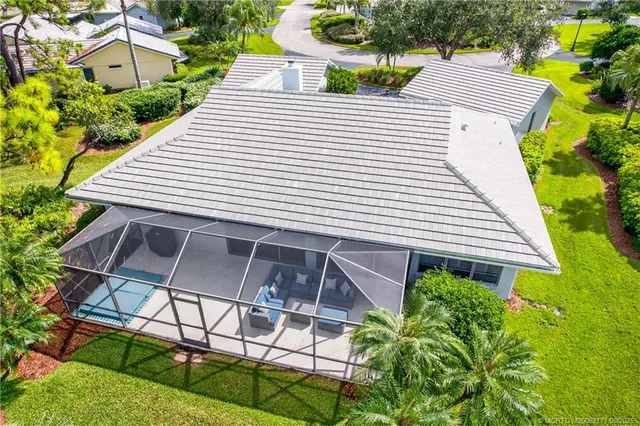 a view of a white house with a yard and potted plants