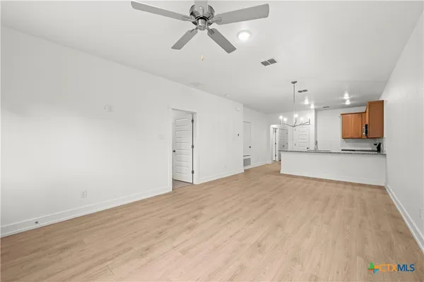 a view of empty room with wooden floor