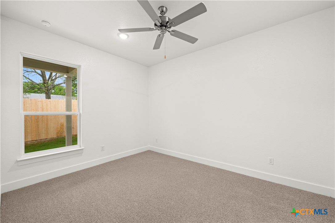 614 Campus Street Troy, TX 76579 - Photo 11 of 18 an empty room with a window and a fan