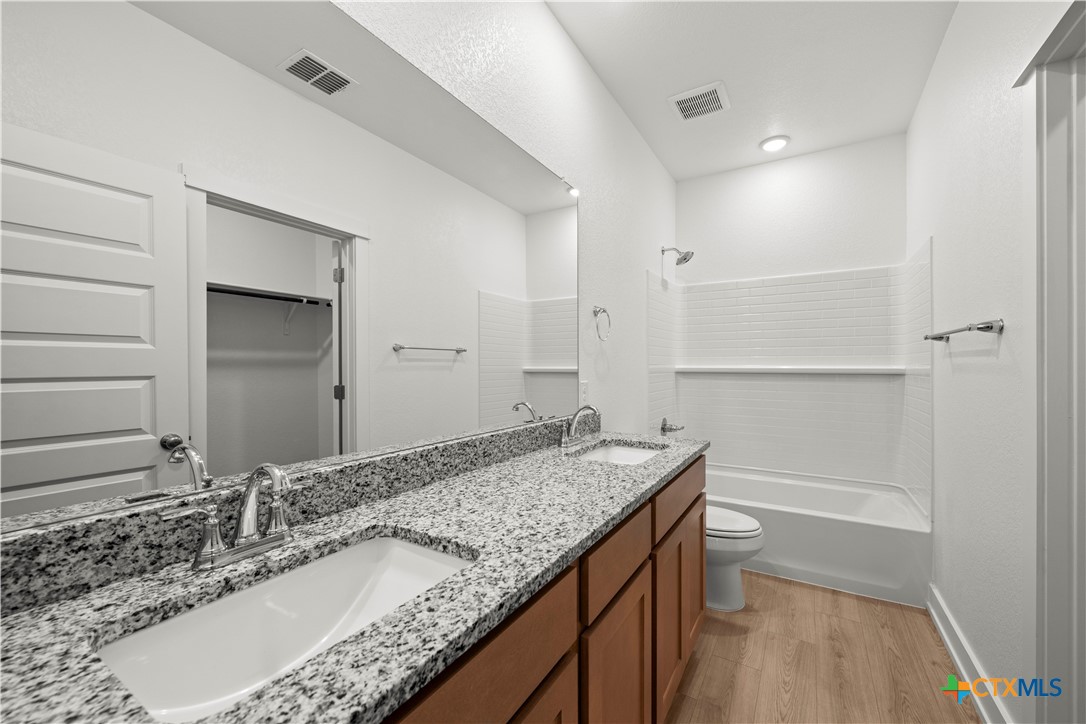614 Campus Street Troy, TX 76579 - Photo 12 of 18 a bathroom with a granite countertop sink a toilet and large mirror