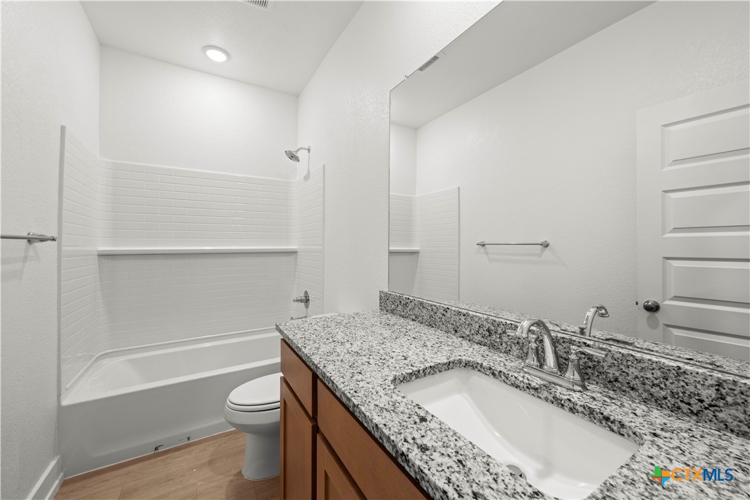 614 Campus Street Troy, TX 76579 - Photo 15 of 18 a bathroom with a granite countertop sink a toilet and bathtub