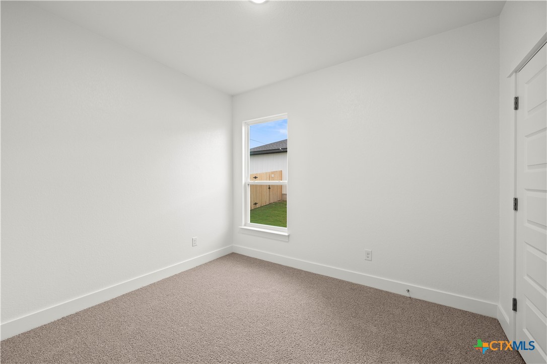 614 Campus Street Troy, TX 76579 - Photo 16 of 18 an empty room with a window and a kitchen