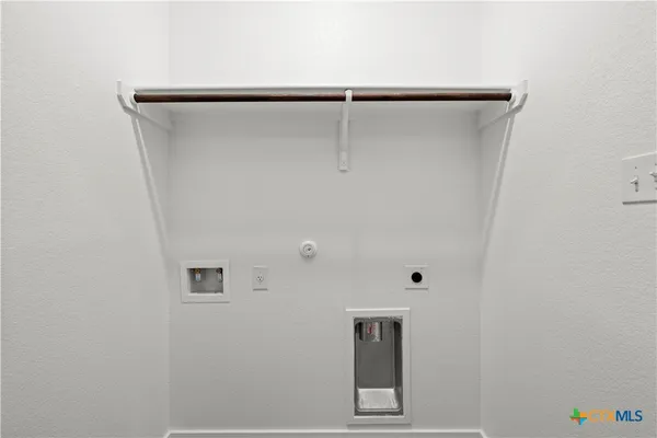 an empty room with a window and a kitchen