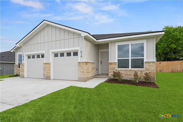 a front view of a house with a yard and outdoor seating