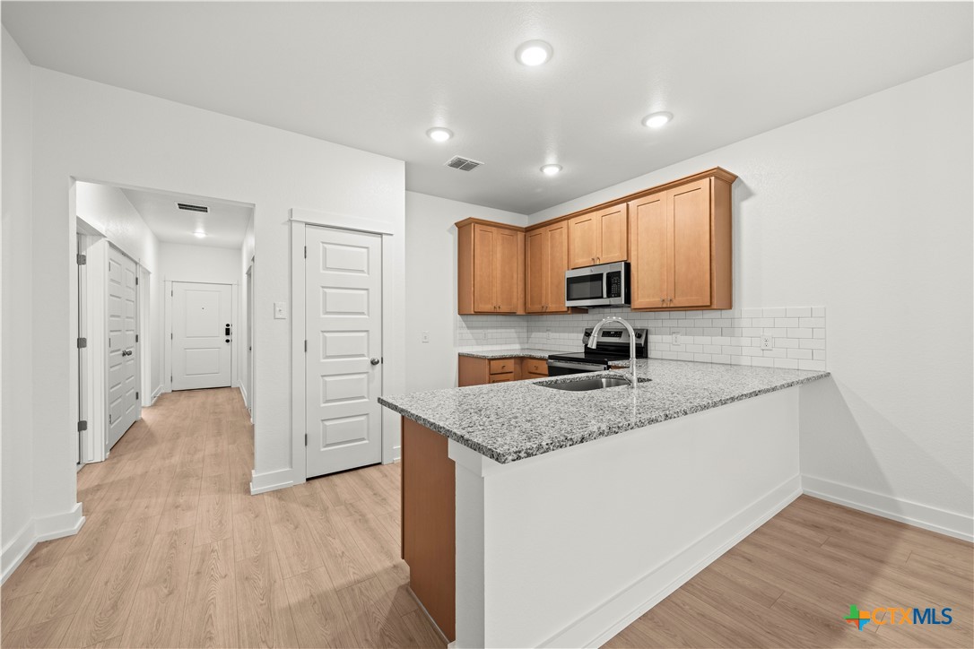 614 Campus Street Troy, TX 76579 - Photo 7 of 18 a kitchen with stainless steel appliances granite countertop a sink stove and refrigerator