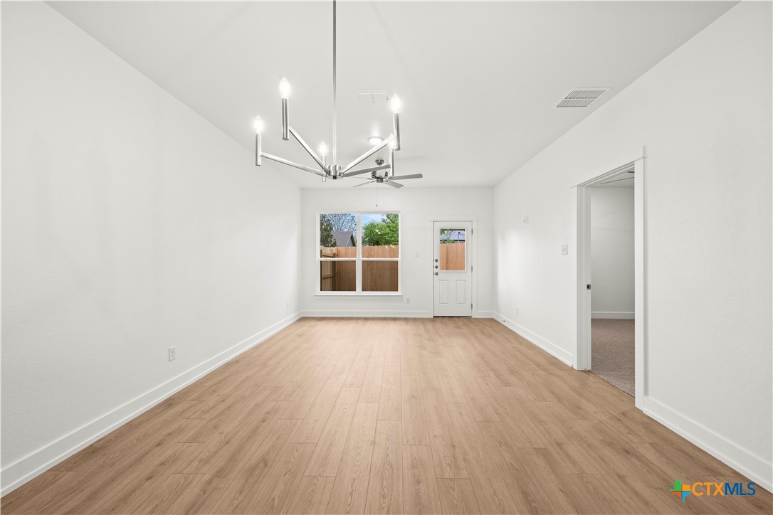 614 Campus Street Troy, TX 76579 - Photo 8 of 18 a view of an empty room with a window and wooden floor