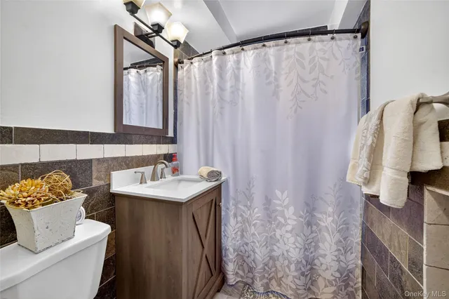 a bathroom with a sink vanity mirror and toilet