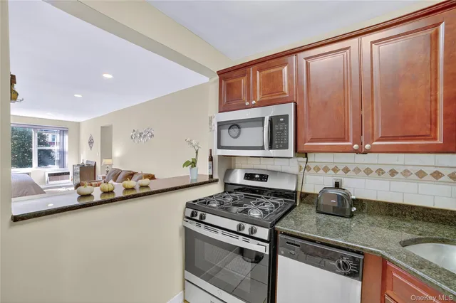 a kitchen with stainless steel appliances granite countertop a sink stove and microwave