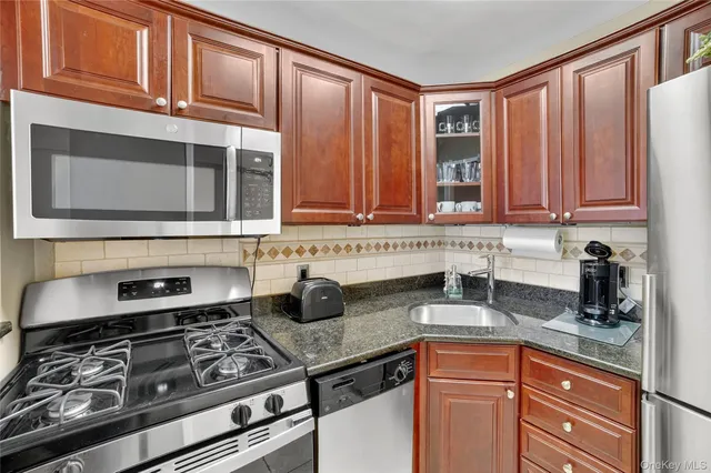 a kitchen with stainless steel appliances granite countertop a stove and a microwave