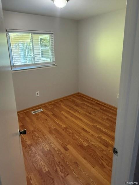 465 Trombley Road Troy, MI 48083 - Photo 9 of 24 Wood-finish flooring with neutral wall tones and a single window with horizontal blinds