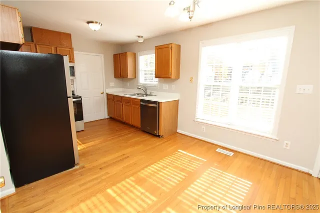 a large kitchen with a refrigerator a stove a sink and a window