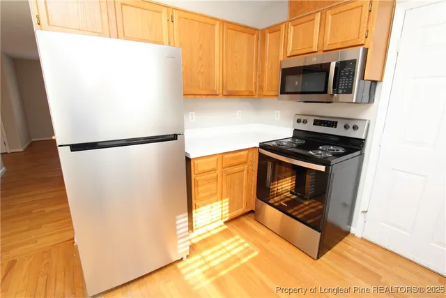 a kitchen with a refrigerator a stove and a microwave