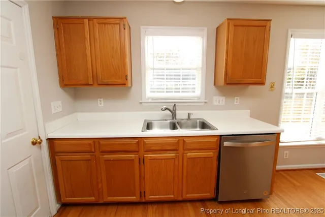 a kitchen with stainless steel appliances granite countertop wooden cabinets a sink and a window