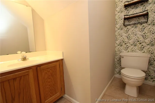 a bathroom with a granite countertop toilet and a sink