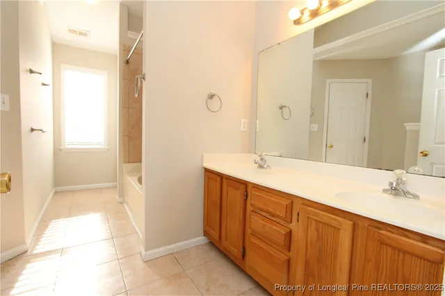 a bathroom with a sink vanity granite tub shower and a mirror