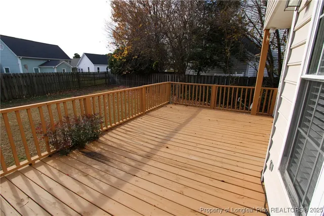 a view of deck with wooden floor and fence and trees
