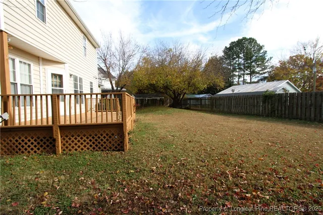 a view of a yard with wooden fence