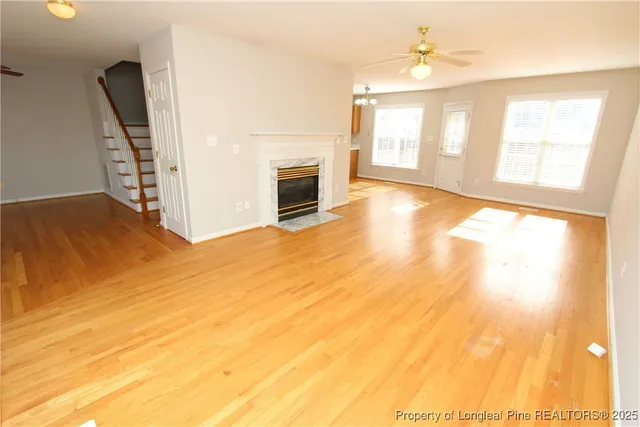 a view of an empty room with a window and fireplace