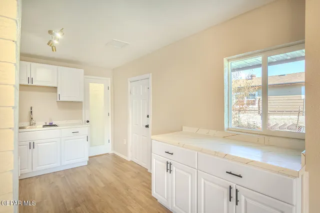 a kitchen with a sink a refrigerator a stove and white cabinets