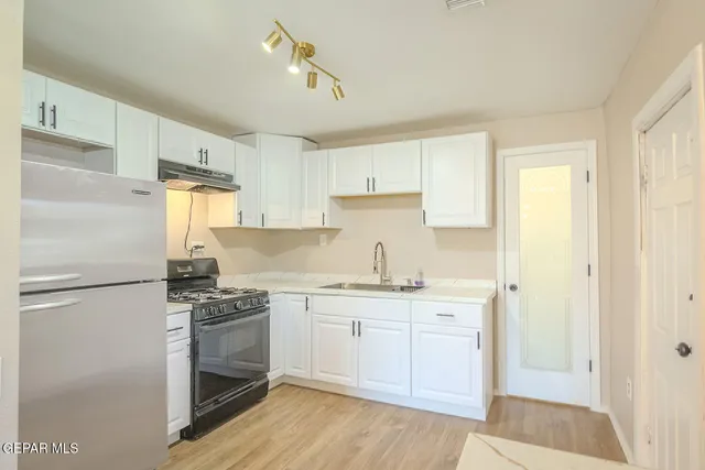 a kitchen with a sink cabinets and wooden floor