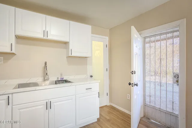 a kitchen with granite countertop a sink cabinets stainless steel appliances and a window