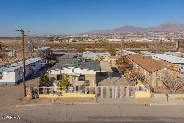 an aerial view of residential houses with outdoor space and ocean view