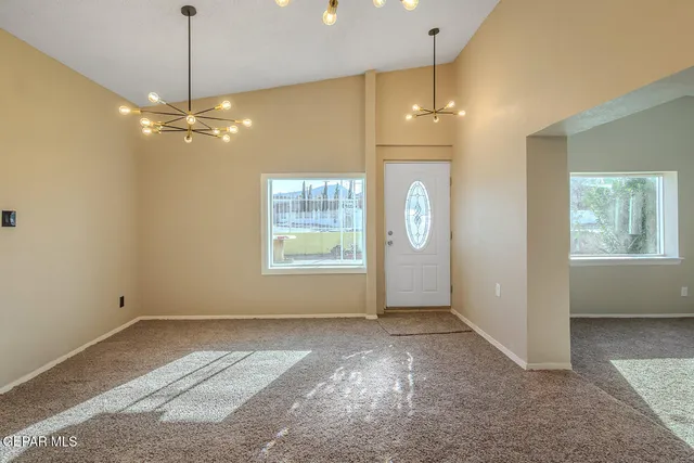 a view of a livingroom with a ceiling fan window and chandelier