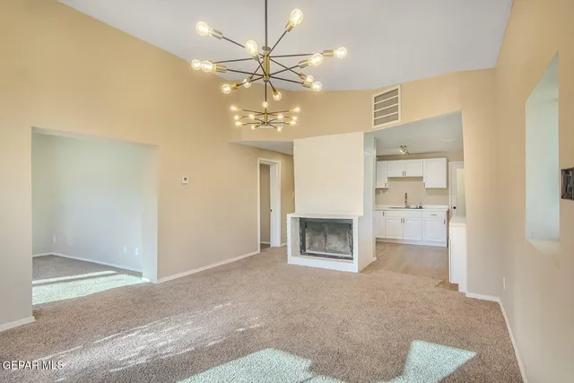 a view of a livingroom with a fireplace a ceiling fan and wooden floor