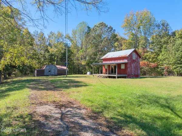 a view of a house with pool and a yard