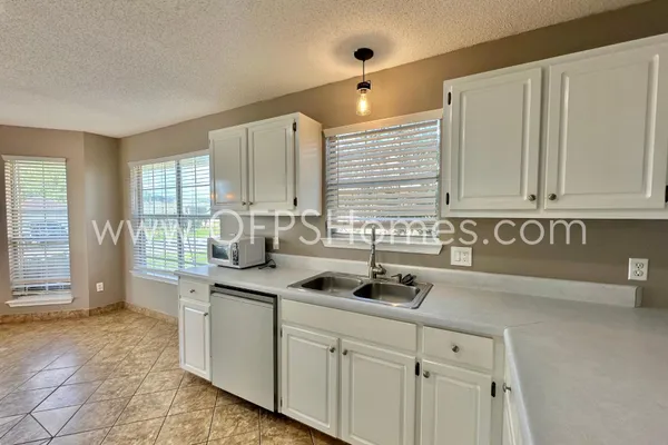 a kitchen with stainless steel appliances granite countertop a sink and a white cabinets