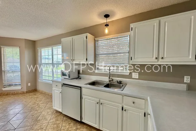 a kitchen with stainless steel appliances granite countertop a sink and a white cabinets