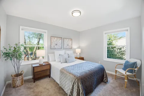 a bedroom with a bed and a potted plant
