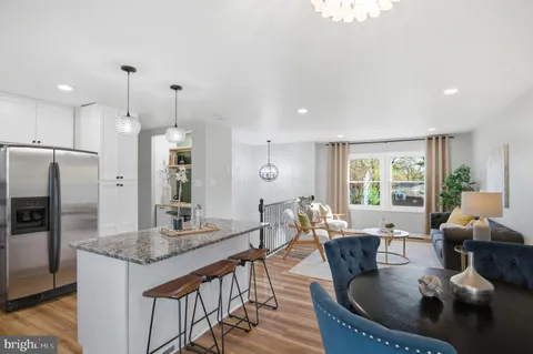 a living room with granite countertop furniture and a kitchen view