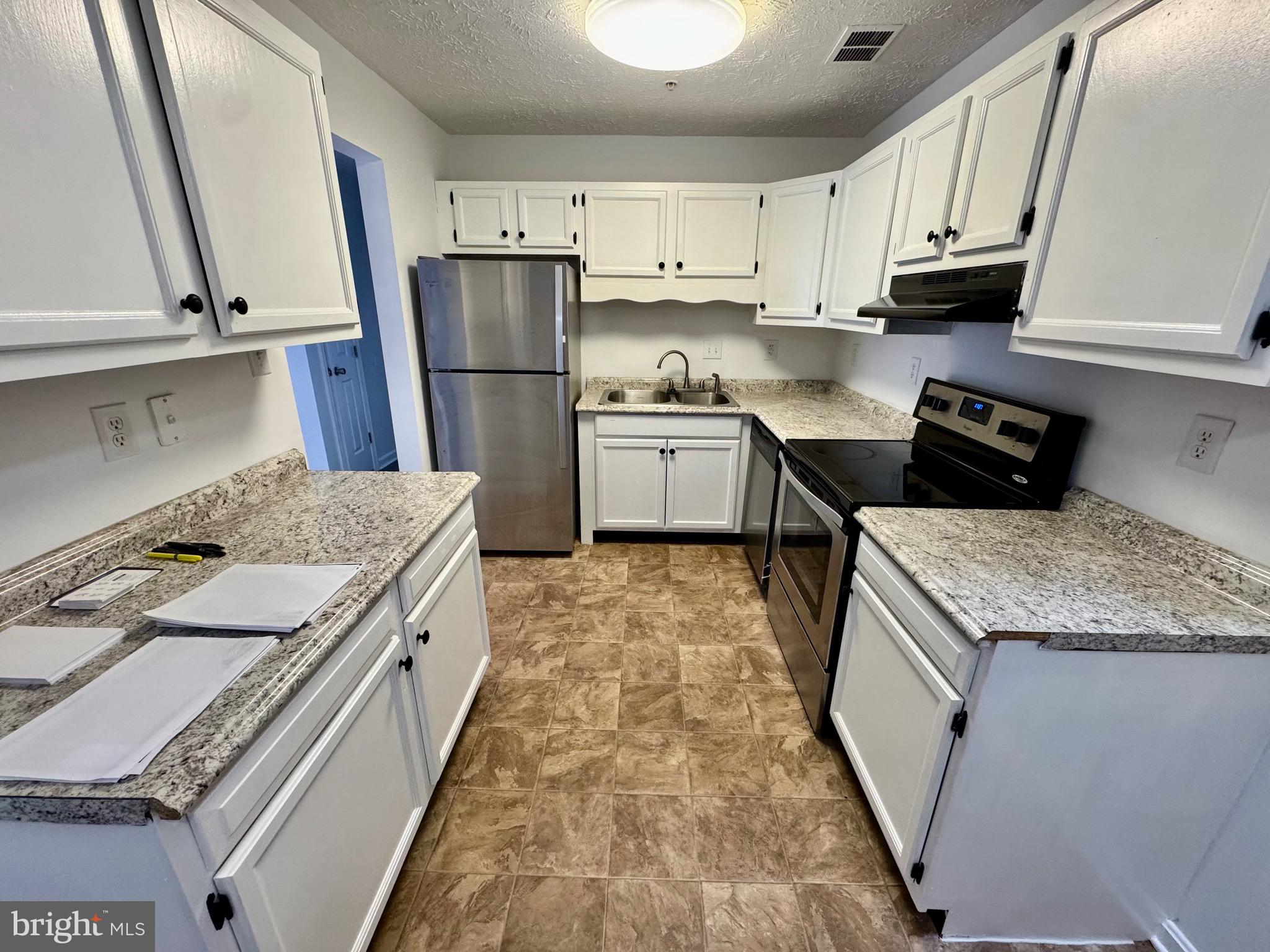1290 South Ox Road Woodstock, VA 22664 - Photo 3 of 13 a kitchen with granite countertop a refrigerator stove and sink