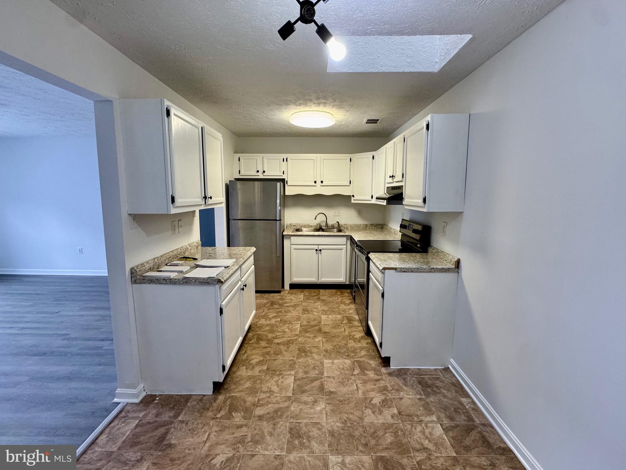 1290 South Ox Road Woodstock, VA 22664 - Photo 5 of 13 a kitchen with refrigerator stove microwave and cabinets