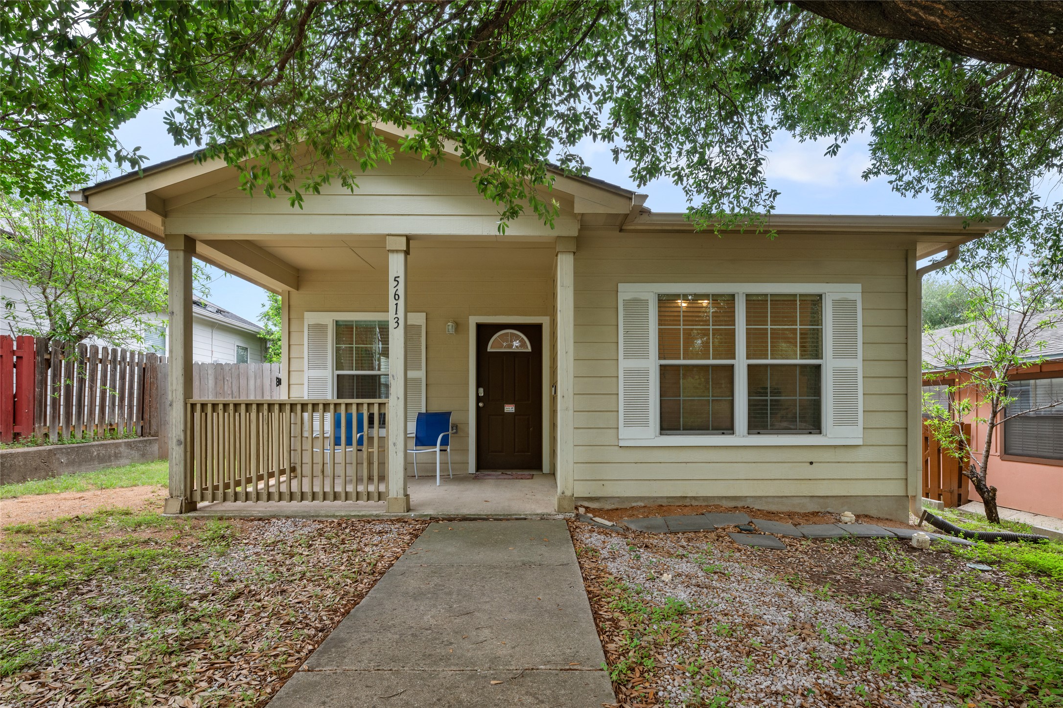 5613 Signal Point Austin, TX 78724 - Photo 1 of 21 Single-story residence featuring a covered front porch with wood railing, tan siding, white window trim, and a dark wood front door with an arched glass insert