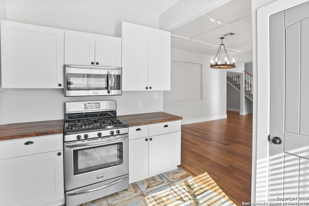 138 Perry Court, Unit 2 San Antonio, TX 78209 - Photo 14 of 29 a kitchen with a stove and white cabinets