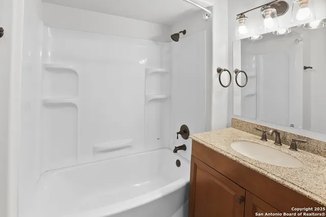 a bathroom with a granite countertop sink mirror toilet and bathtub