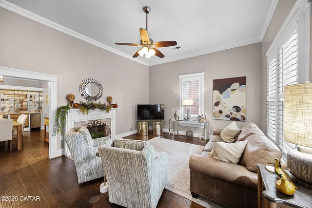 a living room with furniture a ceiling fan and a window