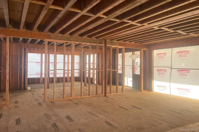 a view of empty room with wooden floor and windows