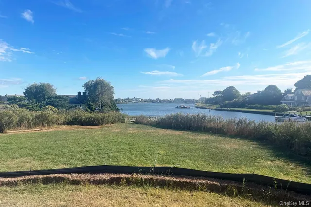 a view of large body of water with lots of green space and fog