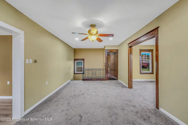 a view of a livingroom with wooden floor and a ceiling fan