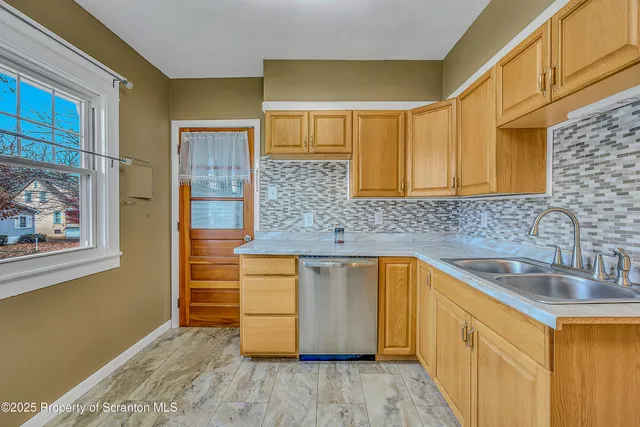 a kitchen with a sink cabinets and a wooden floor