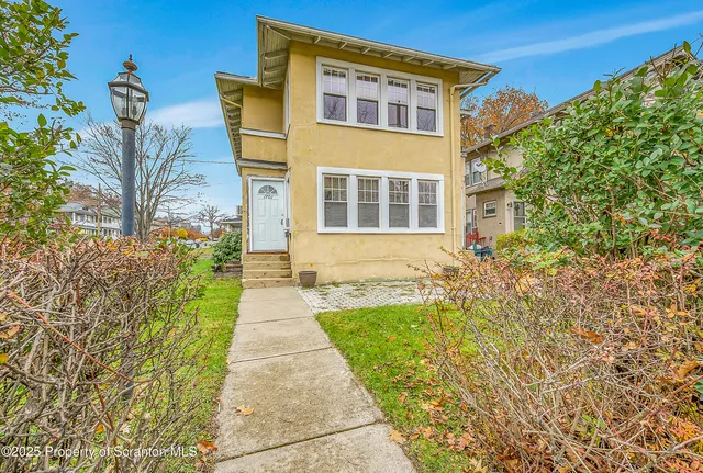 a pathway of a house with a yard