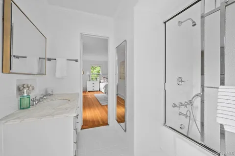 a bathroom with a tub sink and mirror