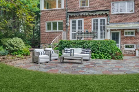 a view of a patio with couches table and chairs and potted plants