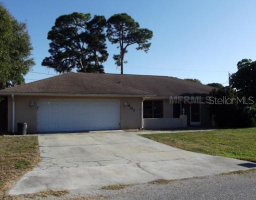 a front view of house with yard and trees in the background