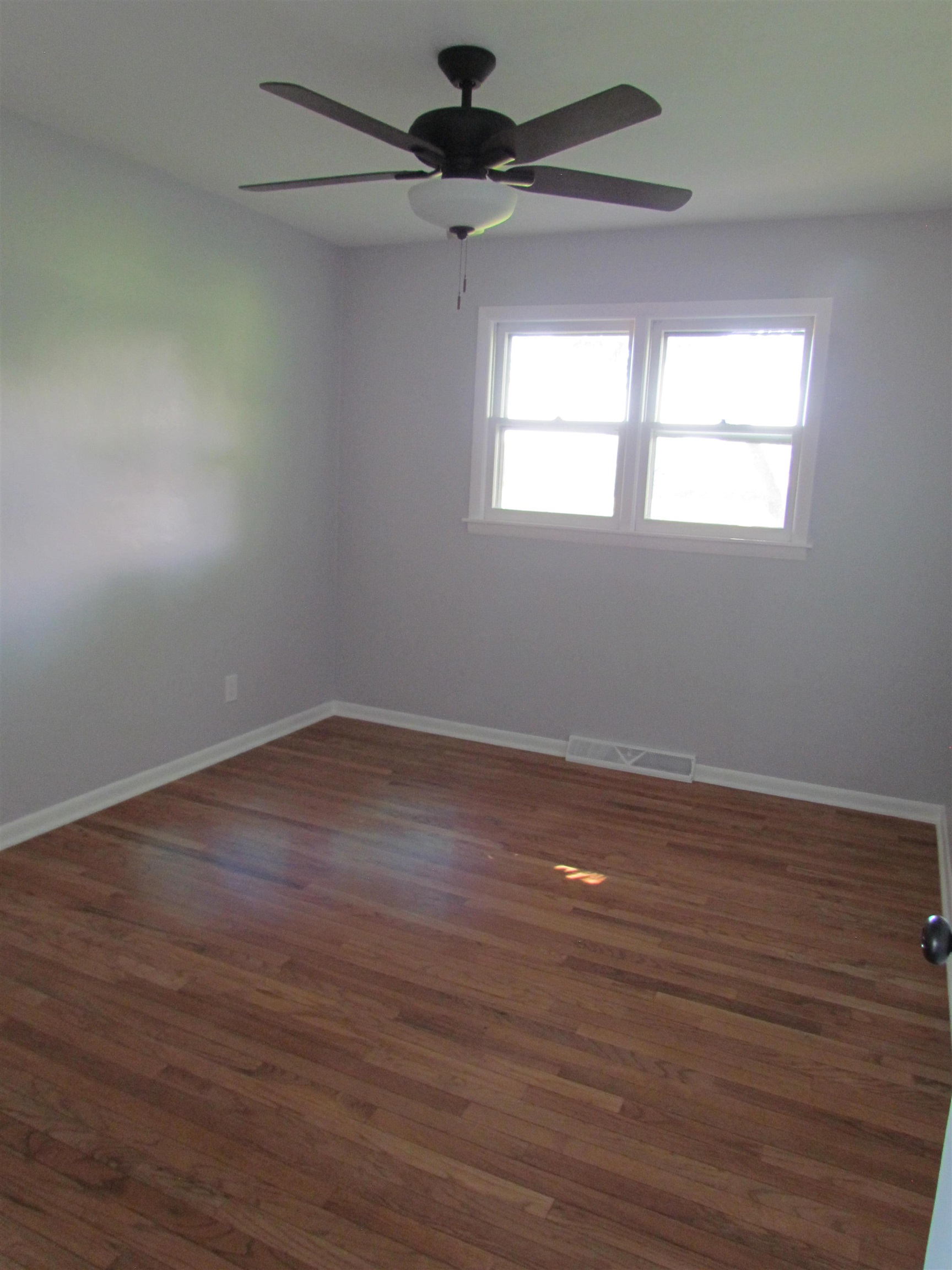 2475 North Pecatonica Road Pecatonica, IL 61063 - Photo 16 of 36 a view of a room that has wooden floor a ceiling fan and windows